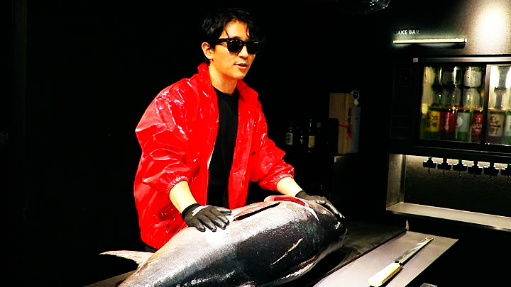 The host with the whole tuna before the cut