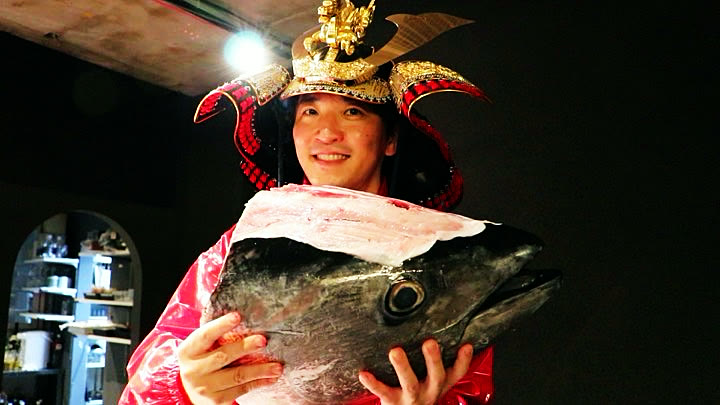 兜姿でマグロの頭を抱える